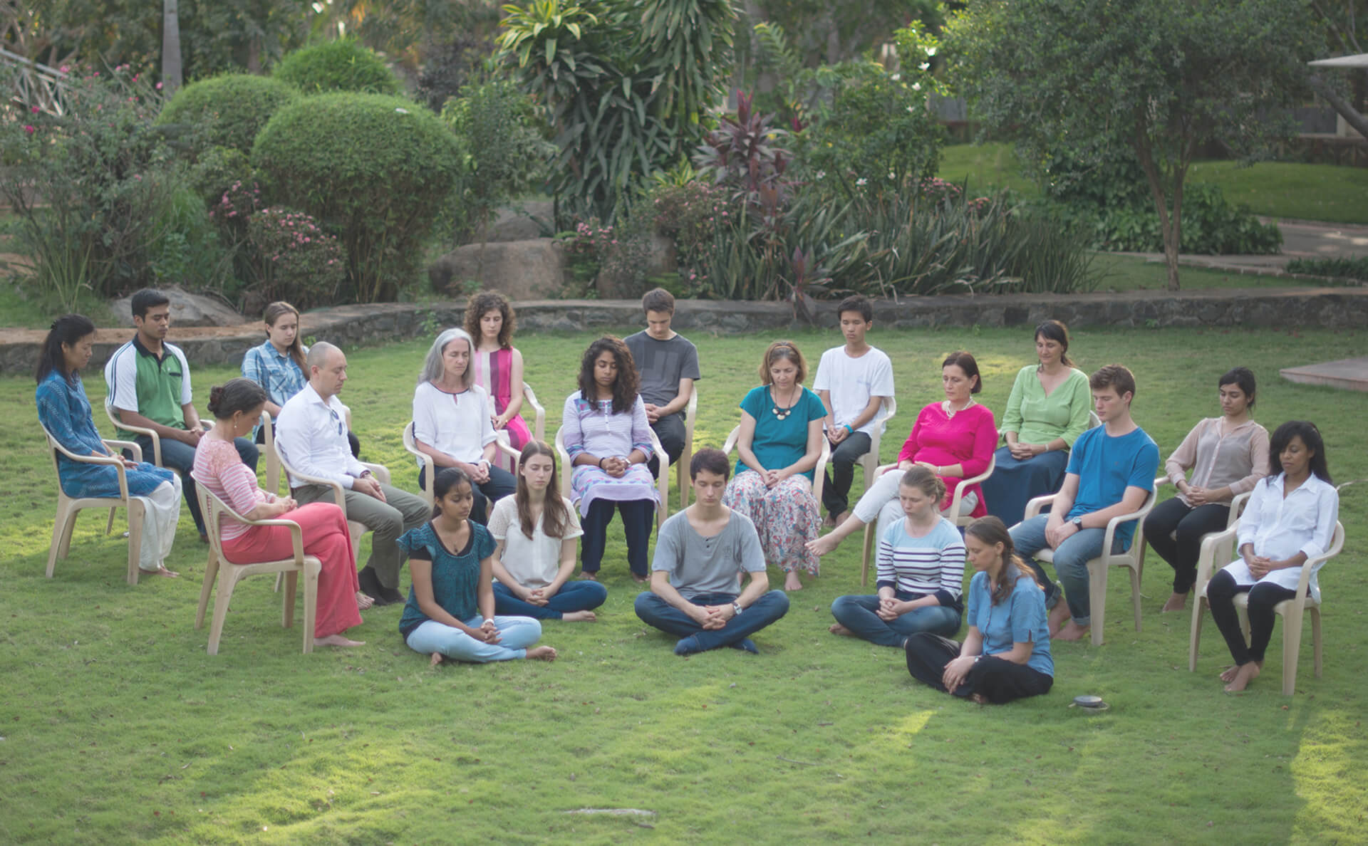 Meditierende aus der Heartfulness Community meditieren zusammen in einem Park.