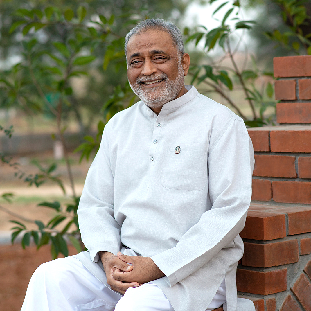 Kamlesh Patel, der Gründer des Heartfulness Instituts, sitzt auf einer Bank in Kanha.