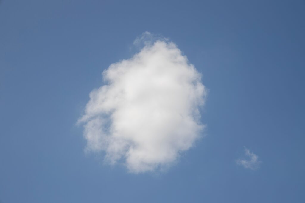 Vor blauem Himmel leuchtet eine weiße Wolke.